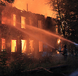 Who covers the damage caused by a fire in an apartment building?